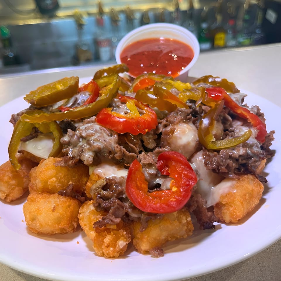 Southwood Bar's loaded tater tots with steak, melted cheese, peppers, and a side of red sauce.