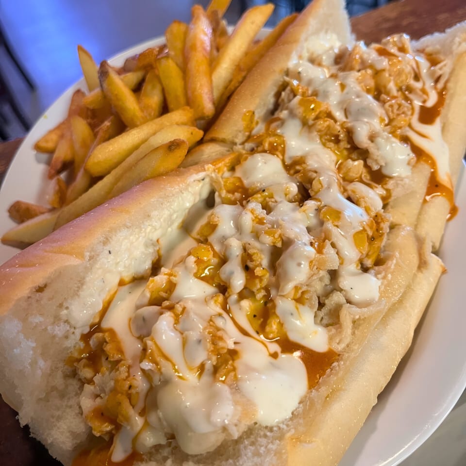 A Southwood Bar buffalo chicken cheesesteak with ranch and buffalo sauce, served with fries.