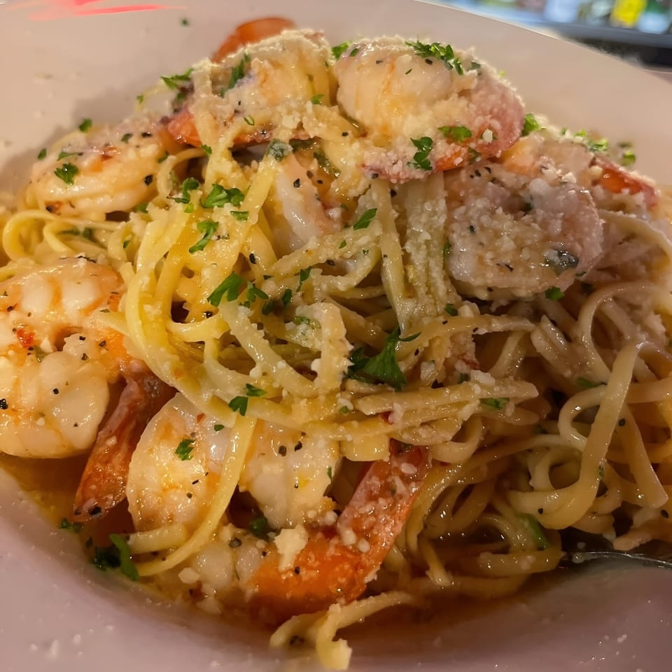 Close-up of Southwood Bar's shrimp scampi with linguine, parmesan, and parsley in a white bowl.